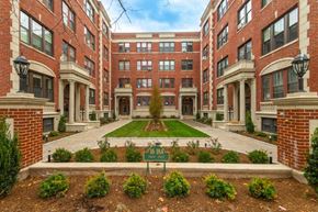 Cambridge apartment for rent - a courtyard between two buildings with a green sign in the middle
