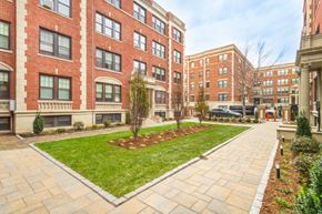 Cambridge apartment for rent - a courtyard with a green lawn in front of a brick building