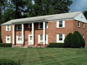 Henrietta apartment for rent - a red brick house with white columns and a lawn