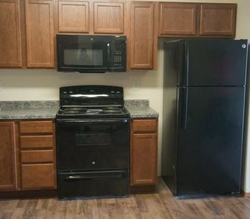 Dickinson apartment for rent - a kitchen with black appliances and wooden cabinets