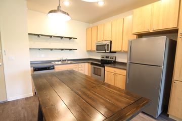 Grand Forks apartment for rent - a kitchen with a wooden table and a stainless steel refrigerator