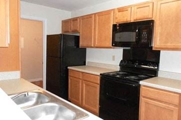 Daphne apartment for rent - a kitchen with black appliances and wooden cabinets