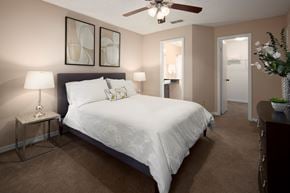 Jacksonville apartment for rent - a bedroom with a large white bed and a ceiling fan