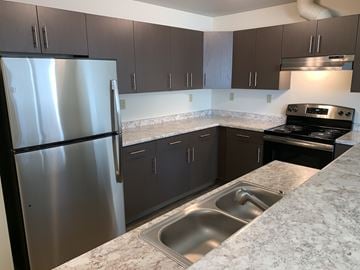 Anchorage apartment for rent - A kitchen with a stainless steel refrigerator and a marble countertop.