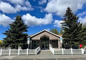 Anchorage apartment for rent - A building with a white picket fence in front of it.