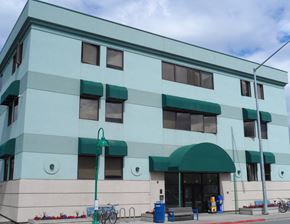 Anchorage apartment for rent - a large building with green awnings and a sidewalk
