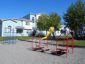 Anchorage townhouse for rent - A playground with a red slide and a blue climbing frame.