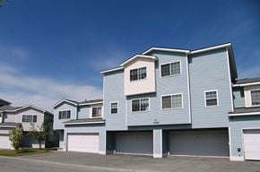 Anchorage townhouse for rent - A large blue house with a garage door.
