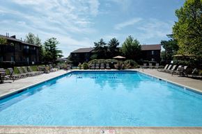 Arlington Heights townhouse for rent - A large swimming pool with a blue water surface and a white fence around it.