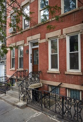 Jersey City apartment for rent - A red brick building with a black iron fence.