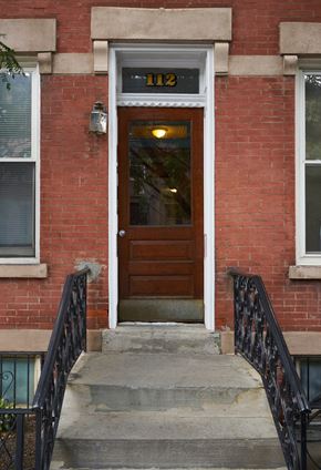 Jersey City apartment for rent - A red brick building with a black iron railing and a black door.