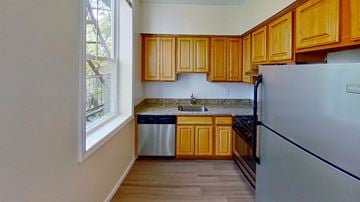 Jersey City apartment for rent - A kitchen with wooden cabinets and a stainless steel refrigerator.