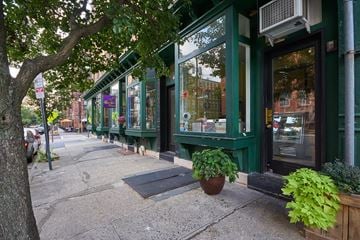Jersey City apartment for rent - A green building with a tree in front of it.