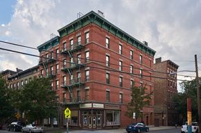 Jersey City apartment for rent - A red brick building with a green roof and a sign that says "Hotel".