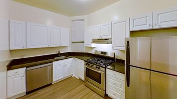 Jersey City apartment for rent - A kitchen with white cabinets and a black stove top.