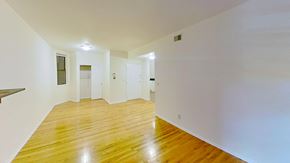 Jersey City apartment for rent - A long hallway with wood floors and white walls.