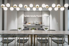 Jersey City apartment for rent - A modern kitchen with a marble countertop and gold chairs.