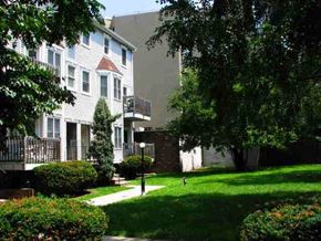 Jersey City apartment for rent - A tree-lined street with a white house on the left.