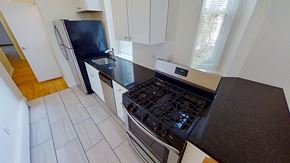 Jersey City apartment for rent - A kitchen with a black stove top oven and white cabinets.