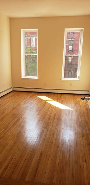 Jersey City apartment for rent - A room with wooden floors and two windows.
