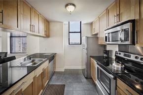 Jersey City apartment for rent - A kitchen with wooden cabinets and stainless steel appliances.