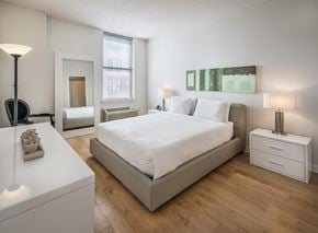 Jersey City apartment for rent - A bedroom with a large bed, a nightstand, and a dresser.