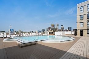 Jersey City apartment for rent - A large outdoor swimming pool with a wooden deck.