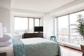 Boston apartment for rent - a bedroom with a bed and a tv and some windows