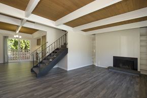 Edmonds townhouse for rent - Spacious Living Room with Plank Flooring, Overhead Exposed Beams, Iron Staircase, and Fireplace at Woodlake Townhomes, Washington, 98026