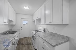 Long Beach apartment for rent - A kitchen with white cabinets and a granite countertop.