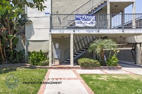 Long Beach apartment for rent - A building with a sign that says "NOW LEASING" and a phone number.