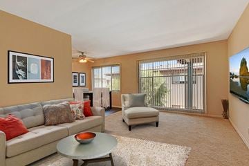 Sherman Oaks apartment for rent - A living room with a grey couch, a round table, and a painting on the wall.