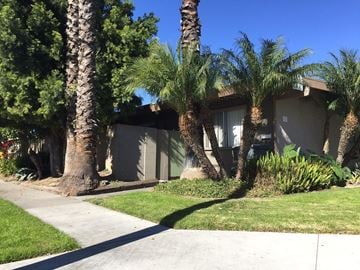 Buena Park apartment for rent - a house with palm trees in front of it on a sidewalk