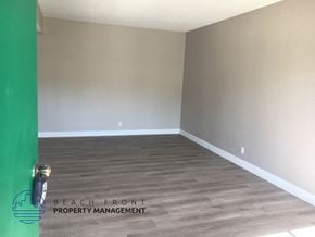 Anaheim apartment for rent - an empty room with wood floors and a green door