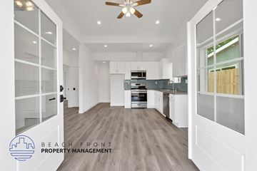 Costa Mesa apartment for rent - A spacious kitchen with white cabinets and a ceiling fan.