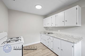 Anaheim apartment for rent - A kitchen with white cabinets and a granite countertop.