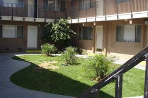 Garden Grove apartment for rent - a building with a balcony and a grassy area in front of it