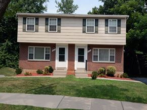 Baltimore apartment for rent - A two-story house with a red brick base and a white top.