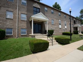 Baltimore apartment for rent - A brick building with a white awning and a black lamp post.