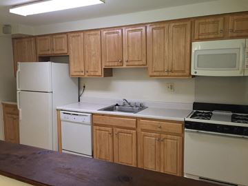 Baltimore apartment for rent - A kitchen with wooden cabinets and white appliances.