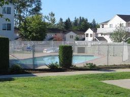 Marysville apartment for rent - a swimming pool in a yard behind a chain link fence