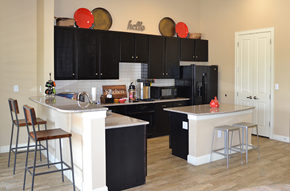 San Antonio apartment for rent - a kitchen with black cabinets and a white island with bar stools