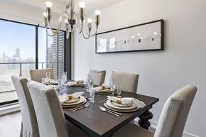 Toronto apartment for rent - A dining room with a table set for six with a chandelier hanging above.