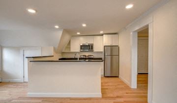 Newton apartment for rent - A kitchen with a white counter and stainless steel appliances.