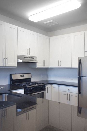 Newark apartment for rent - a kitchen with white cabinets and a stove and a refrigerator