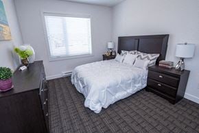 Brandon townhouse for rent - a bedroom with a bed and a dresser and a window