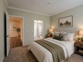Cherry Hill apartment for rent - A bedroom with a large bed and a painting on the wall.