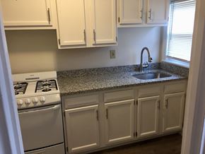 Quincy apartment for rent - Renovated kitchen with granite counters, white cabinets and white appliances