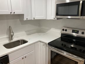 Quincy apartment for rent - Renovated kitchen with white cabinets, quartz counters and stainless appliances