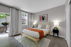 Eugene apartment for rent - A bedroom with a bed, nightstand, and window with curtains.